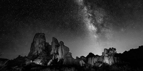 Obraz hviezdna obloha nad skalami v čiernobielom prevedení