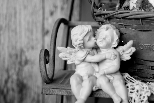 Obraz sošky anjelikov na lavičke v čiernobielom prevedení