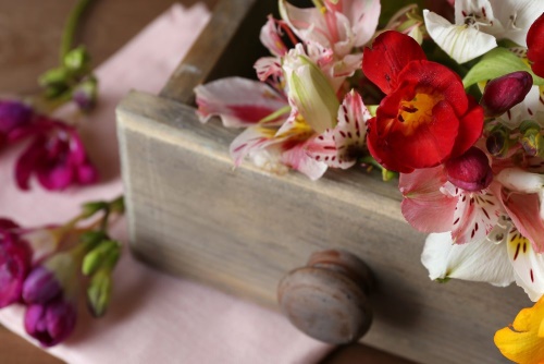 Obraz kompozícia jarných kvetov v drevenom šuplíku