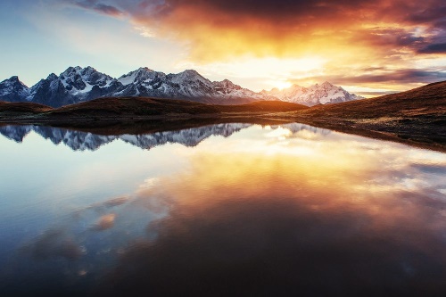 Fototapeta oslnivý západ slnka nad horským jazerom